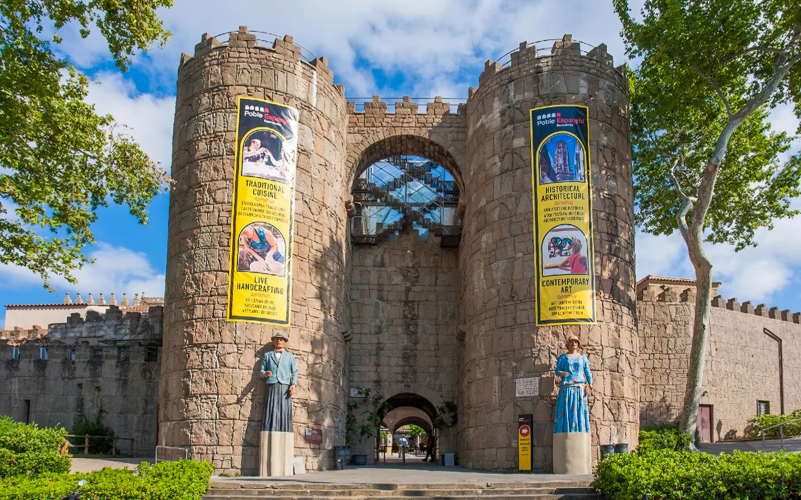 Poble Espanyol entrance in Barcelona with traditional architecture banners.