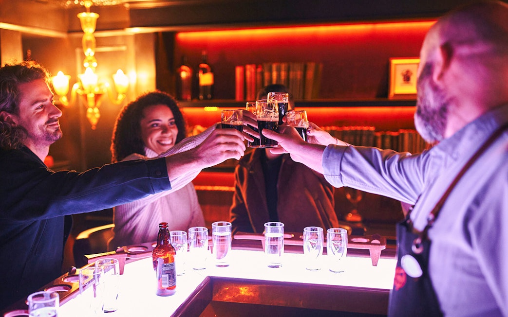 Group toasting with Guinness at Dublin's Connoisseur Experience bar.
