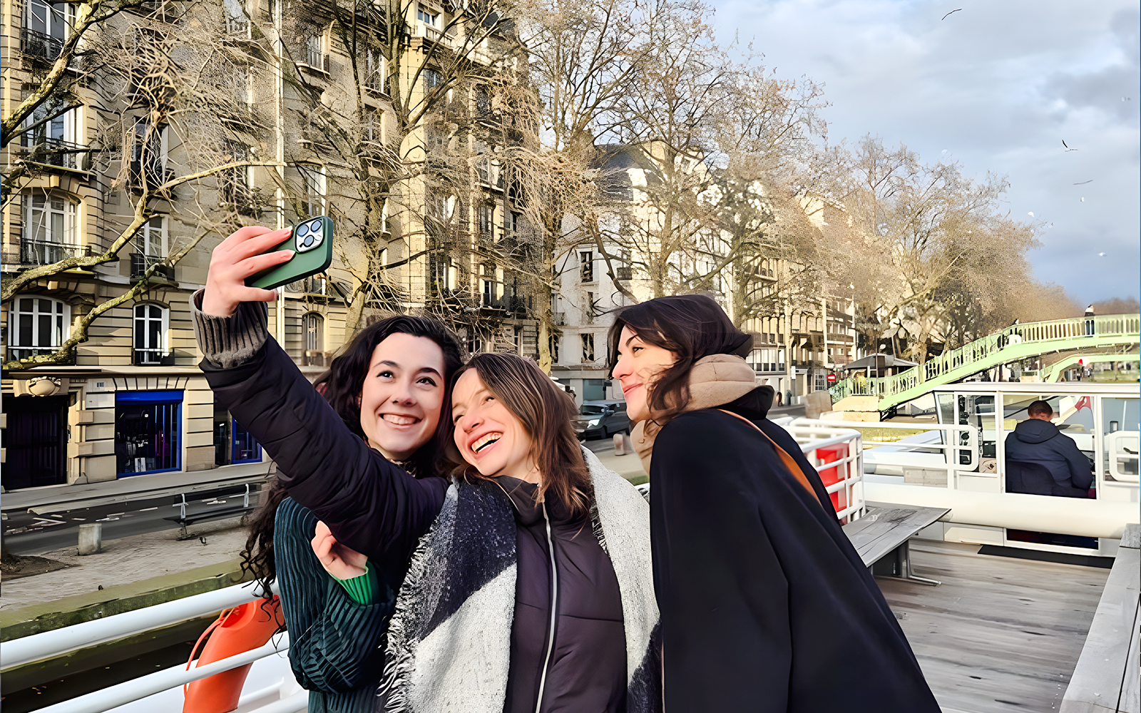 Group taking a selfie on a Seine River canal cruise in Paris, France.