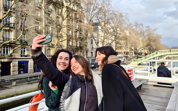 Group taking a selfie on a Seine River canal cruise in Paris, France.