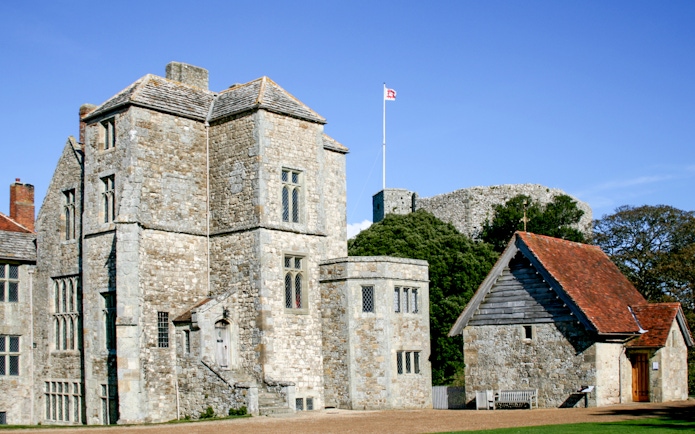 Carisbrooke Castle stone buildings with flag on tower, Isle of Wight, England.