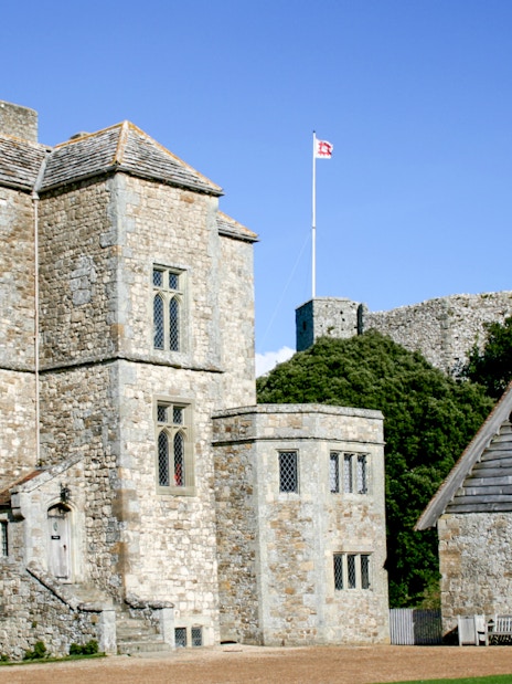 Carisbrooke Castle stone buildings with flag on tower, Isle of Wight, England.
