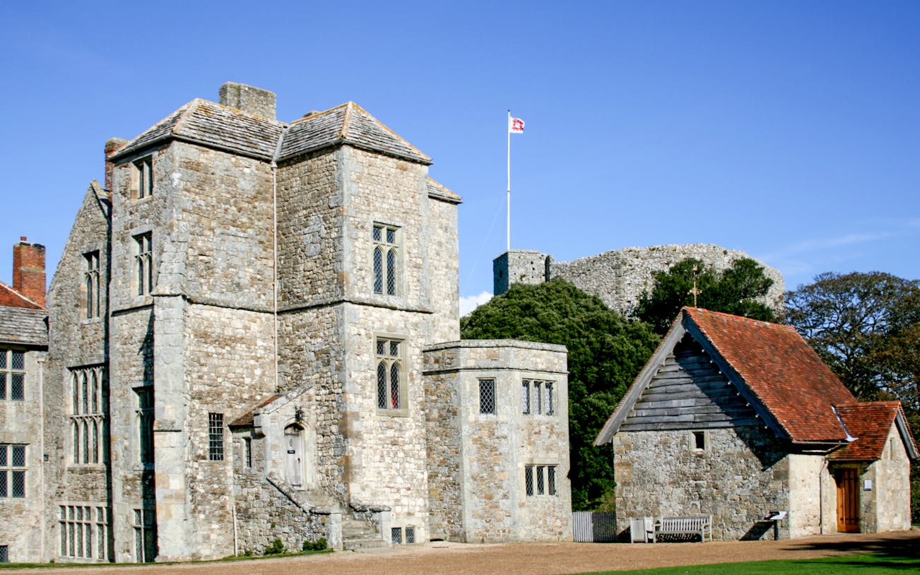 Carisbrooke Castle stone buildings with flag on tower, Isle of Wight, England.