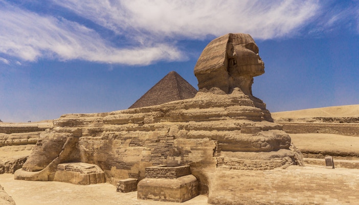 Sphinx and Pyramid in Giza under a clear blue sky.