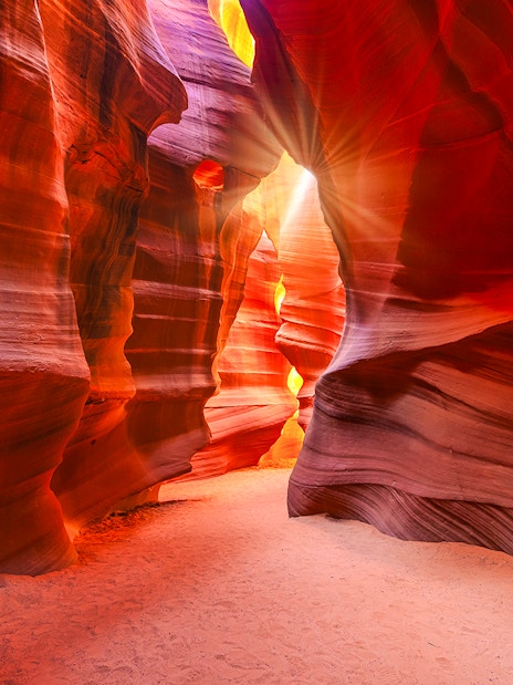 Lower Antelope Canyon's vibrant sandstone walls with sunlight streaming through.