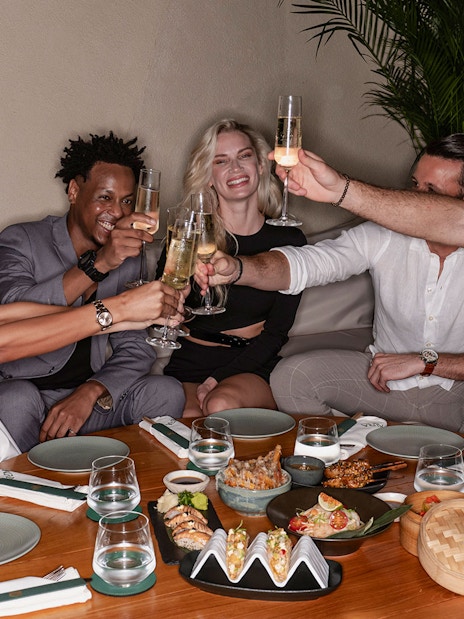 Group enjoying a meal and drinks at Aura Sky Pool.