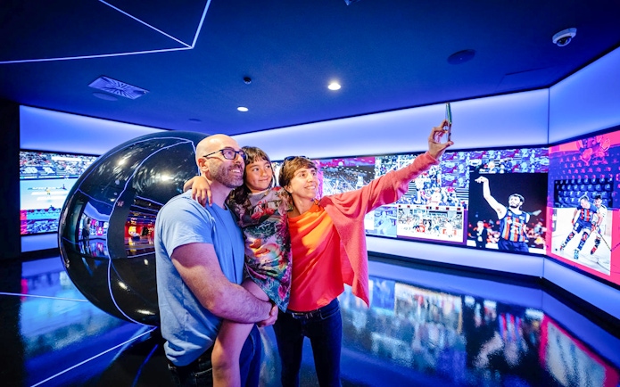 Family taking a selfie at the Barça Museum in Spotify Camp Nou, Barcelona.