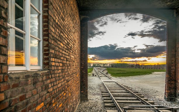 Rail tracks leading into Auschwitz-Birkenau at sunset, Poland.