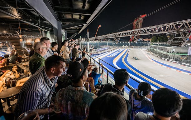 Spectators enjoying the Formula 1 Singapore Grand Prix 2025 from a hospitality suite overlooking the track.