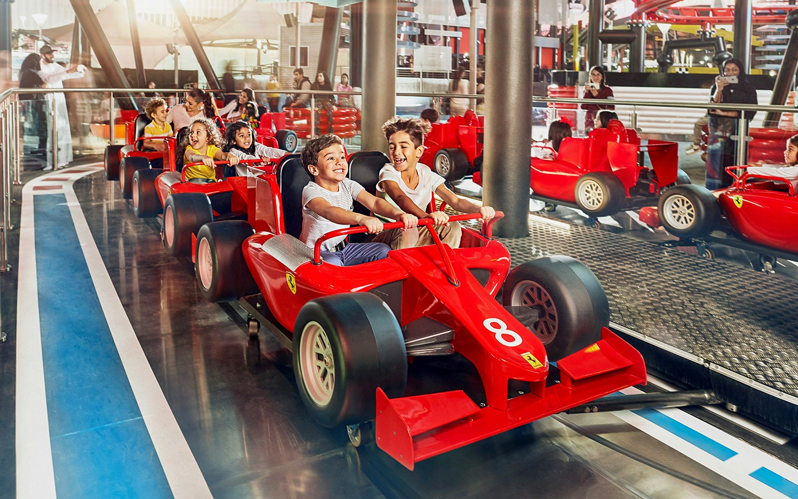 Children enjoying a ride in mini Ferrari cars at Ferrari World Abu Dhabi.