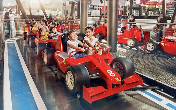 Children enjoying a ride in mini Ferrari cars at Ferrari World Abu Dhabi.