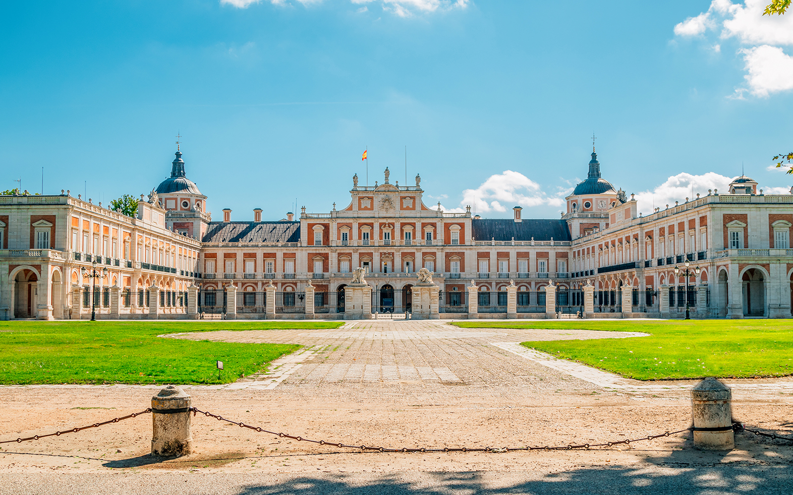 Royal Palace of Aranjuez exterior with manicured gardens in Aranjuez, Spain.