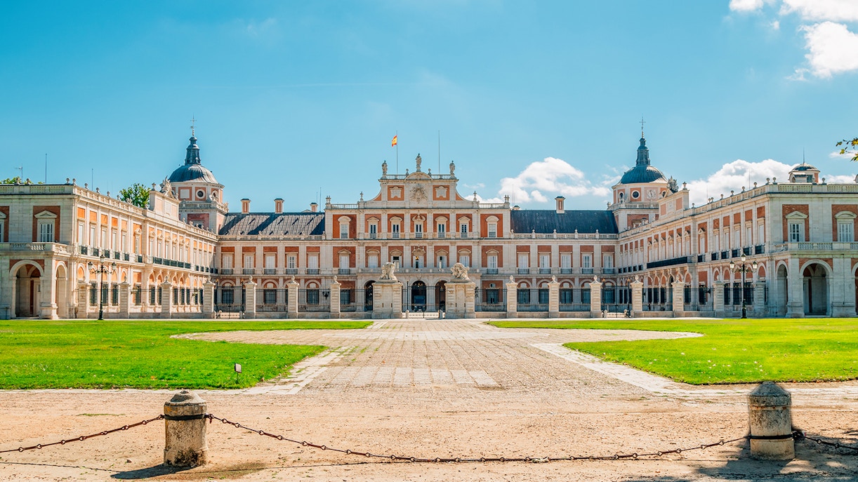 Royal Palace of Aranjuez exterior with manicured gardens in Aranjuez, Spain.