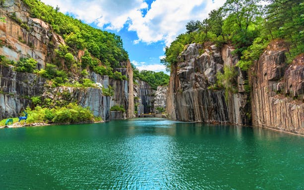 Pocheon Art Valley cliffs and lake on a sunny day during Seoul exploration tour.