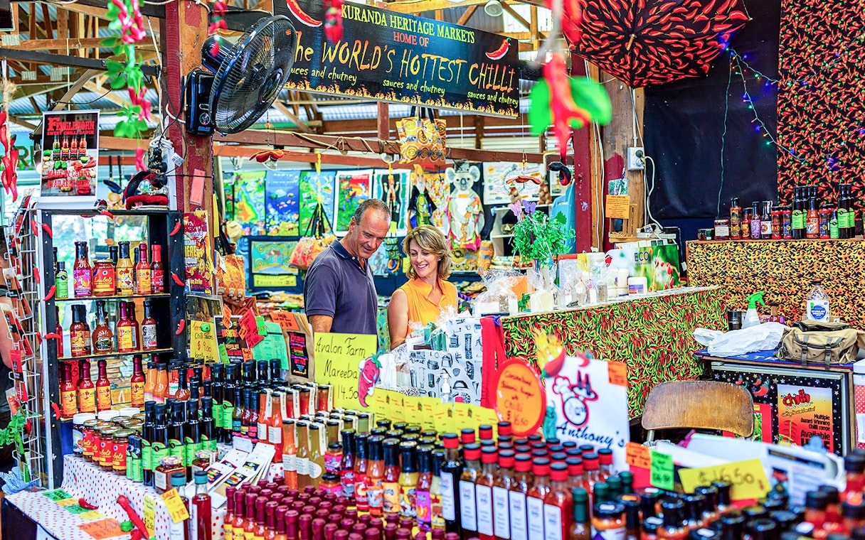 Couple exploring spice stall at Kuranda Heritage Market.