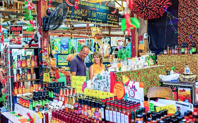 Couple exploring spice stall at Kuranda Heritage Market.