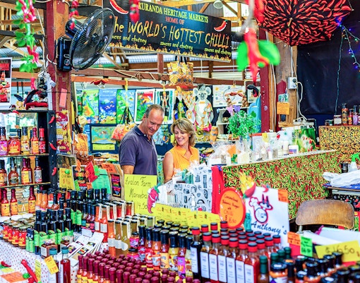 Couple exploring spice stall at Kuranda Heritage Market.