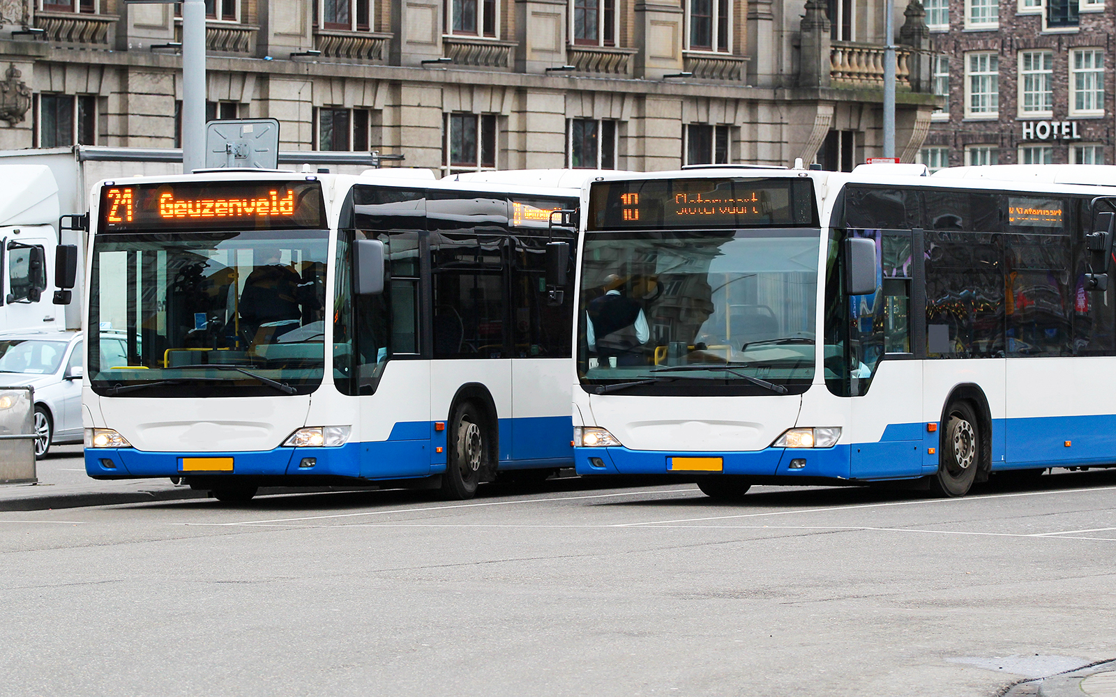 Amsterdam city buses at a stop, showcasing GVB public transport options.