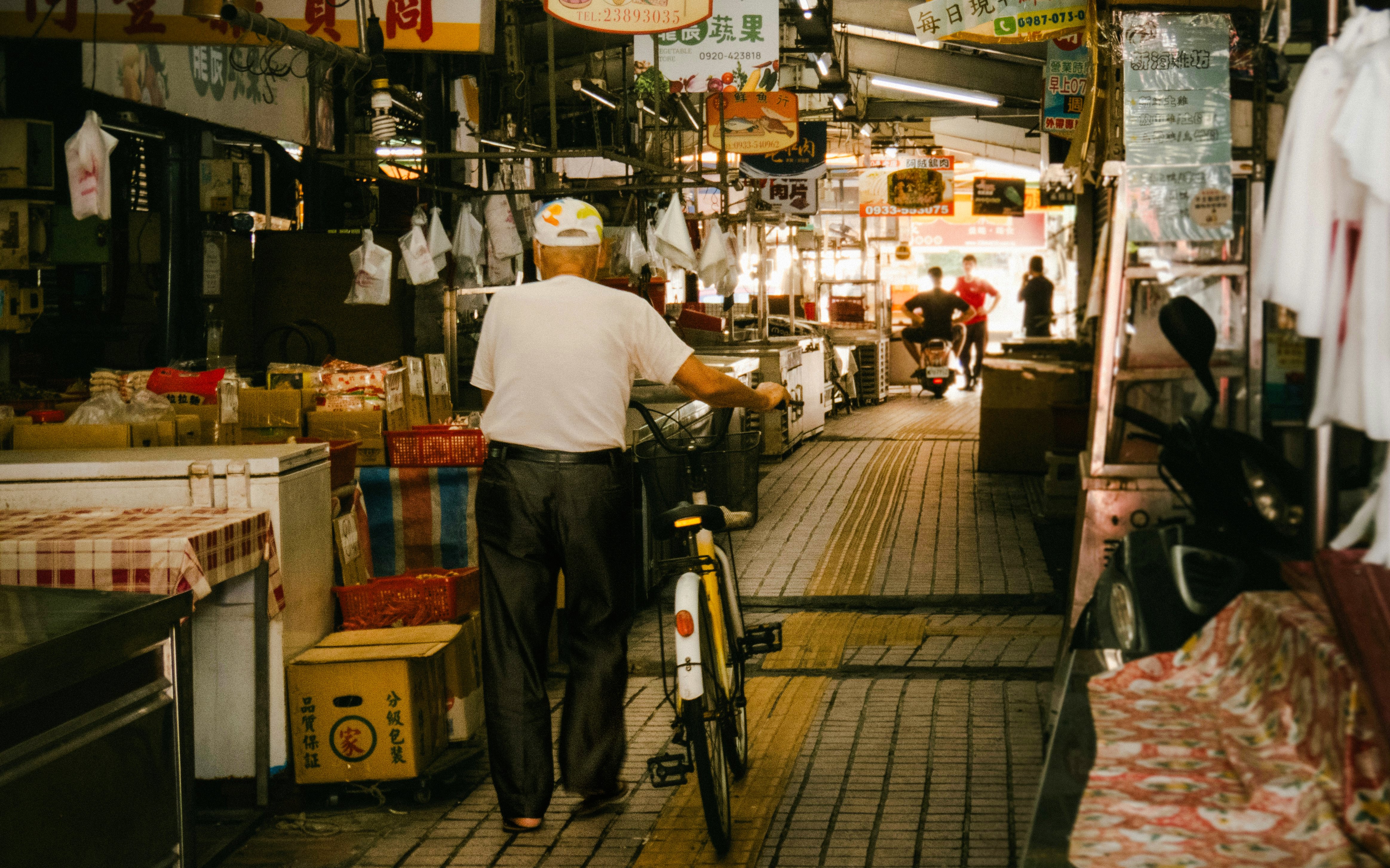 Man with bicycle walking through Tsukiji Outer Market in Tokyo, Japan.