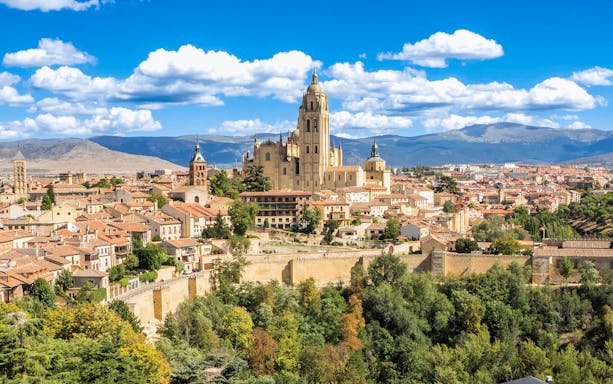 Segovia Cathedral towering over the historic cityscape with mountains in the background.