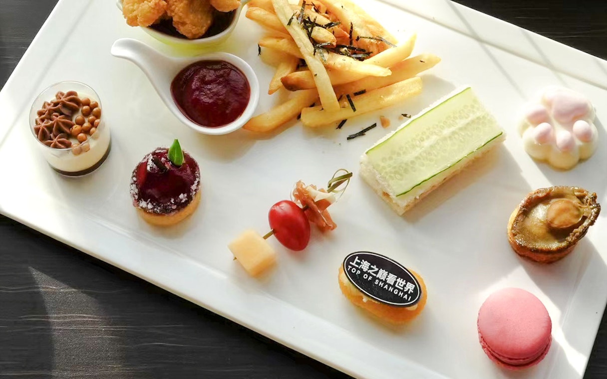 Shanghai Tower restaurant meal with assorted appetizers and desserts on a white plate.