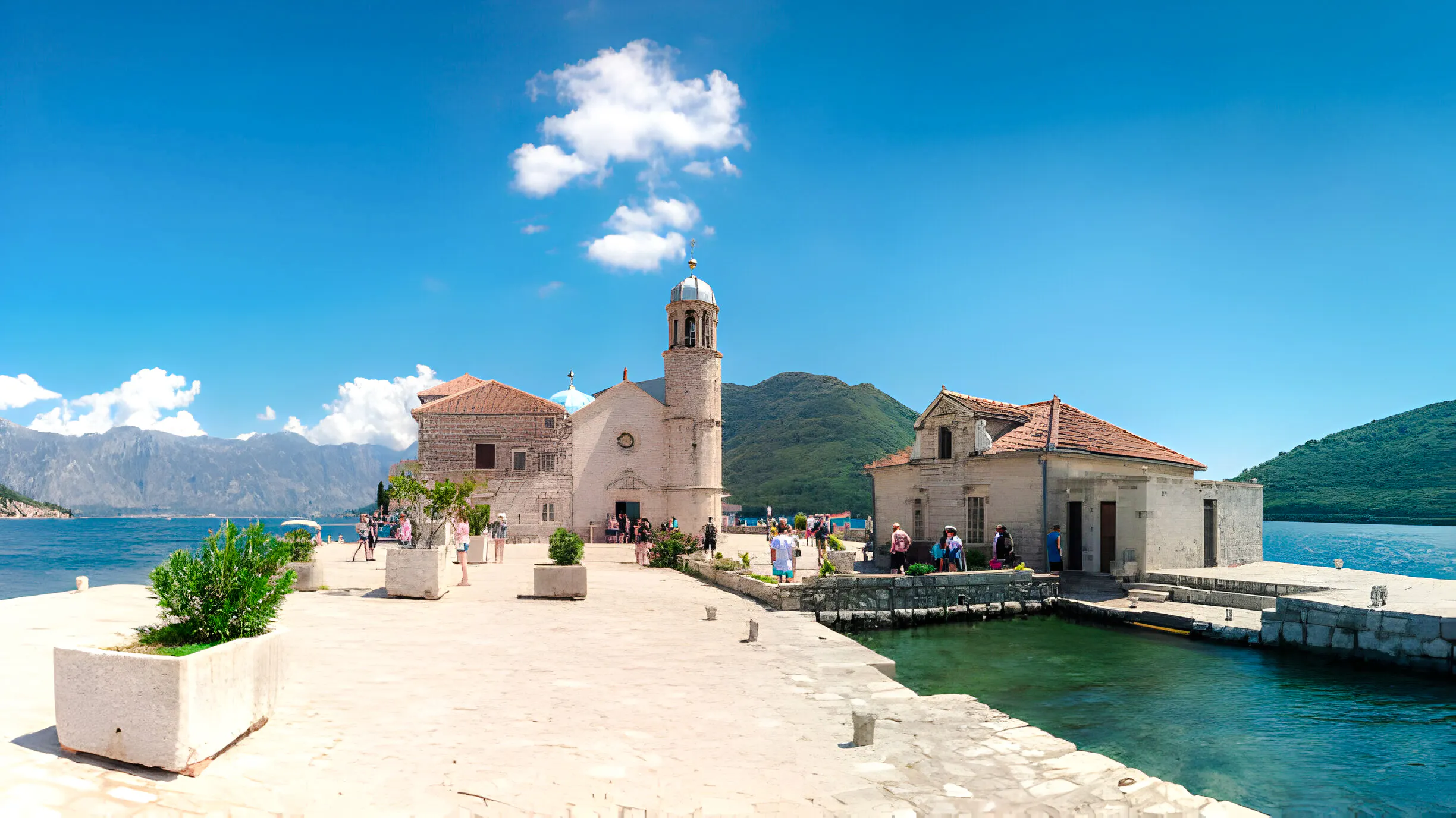 Our Lady of the Rocks church on an islet near Perast, with tourists exploring, Kotor Bay.