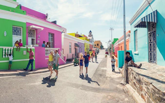 Colorful houses and people in Bo-Kaap neighborhood, Cape Town, South Africa.
