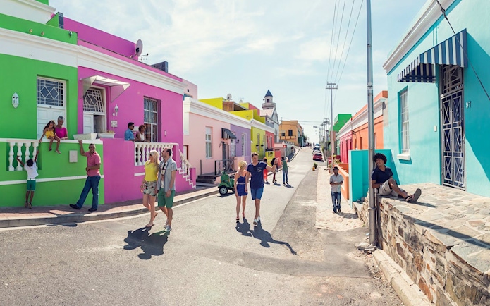 Colorful houses and people in Bo-Kaap neighborhood, Cape Town, South Africa.