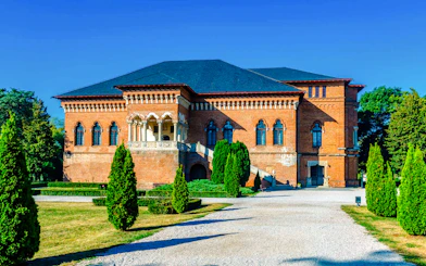Mogosoaia Palace in Romania with its red brick facade and manicured gardens.