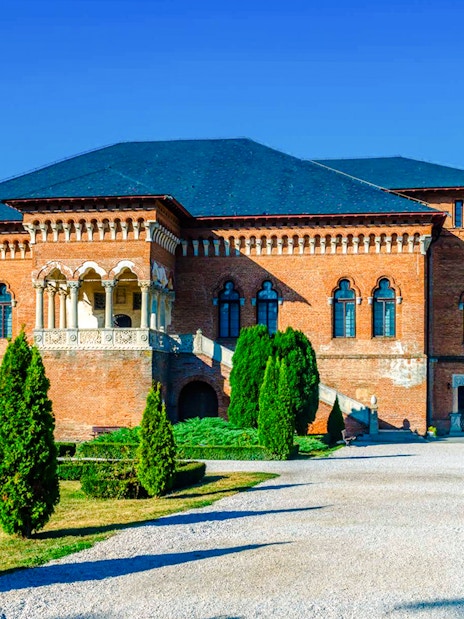 Mogosoaia Palace in Romania with its red brick facade and manicured gardens.