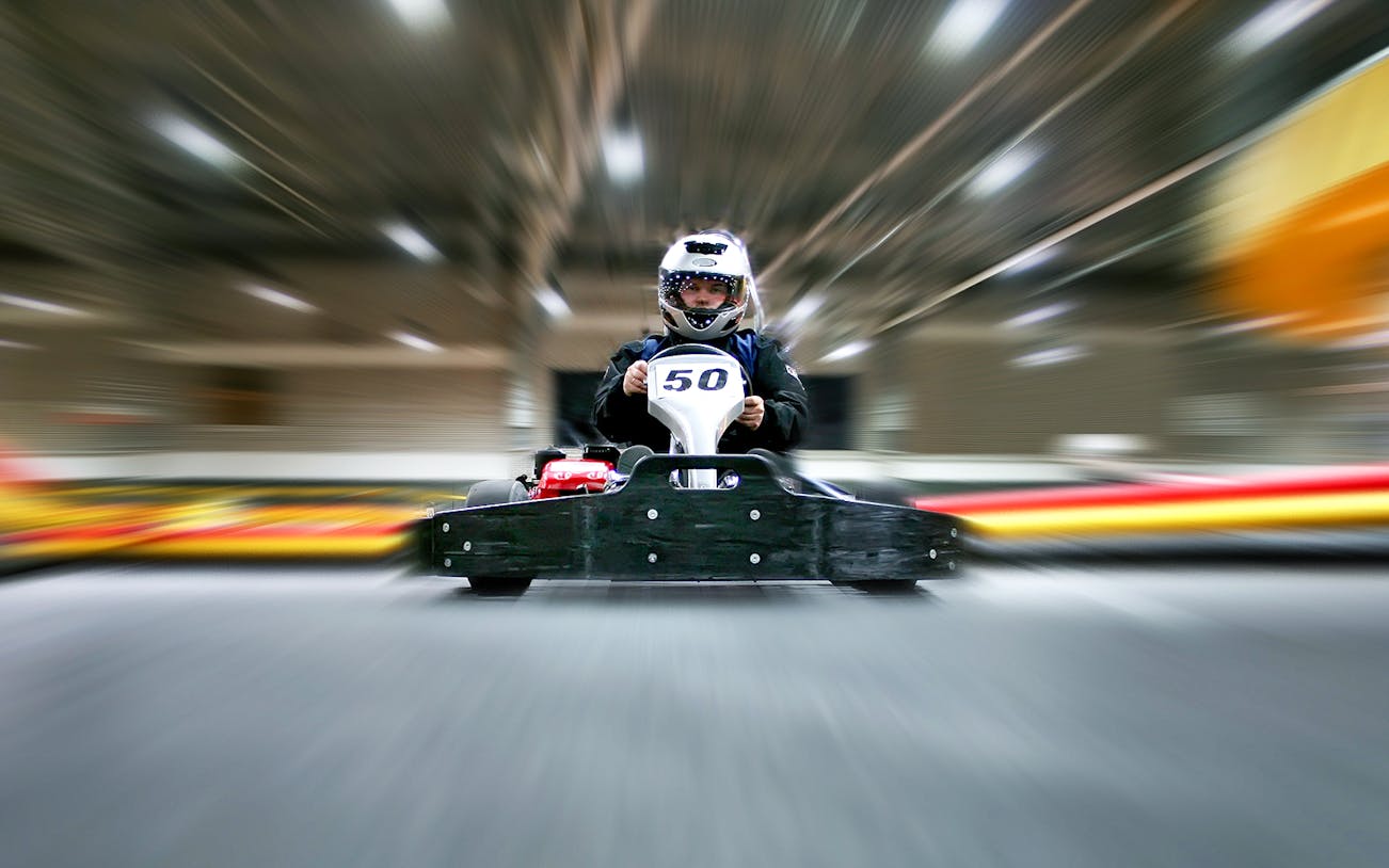 Go-kart racing at Dubai Autodrome indoor track.