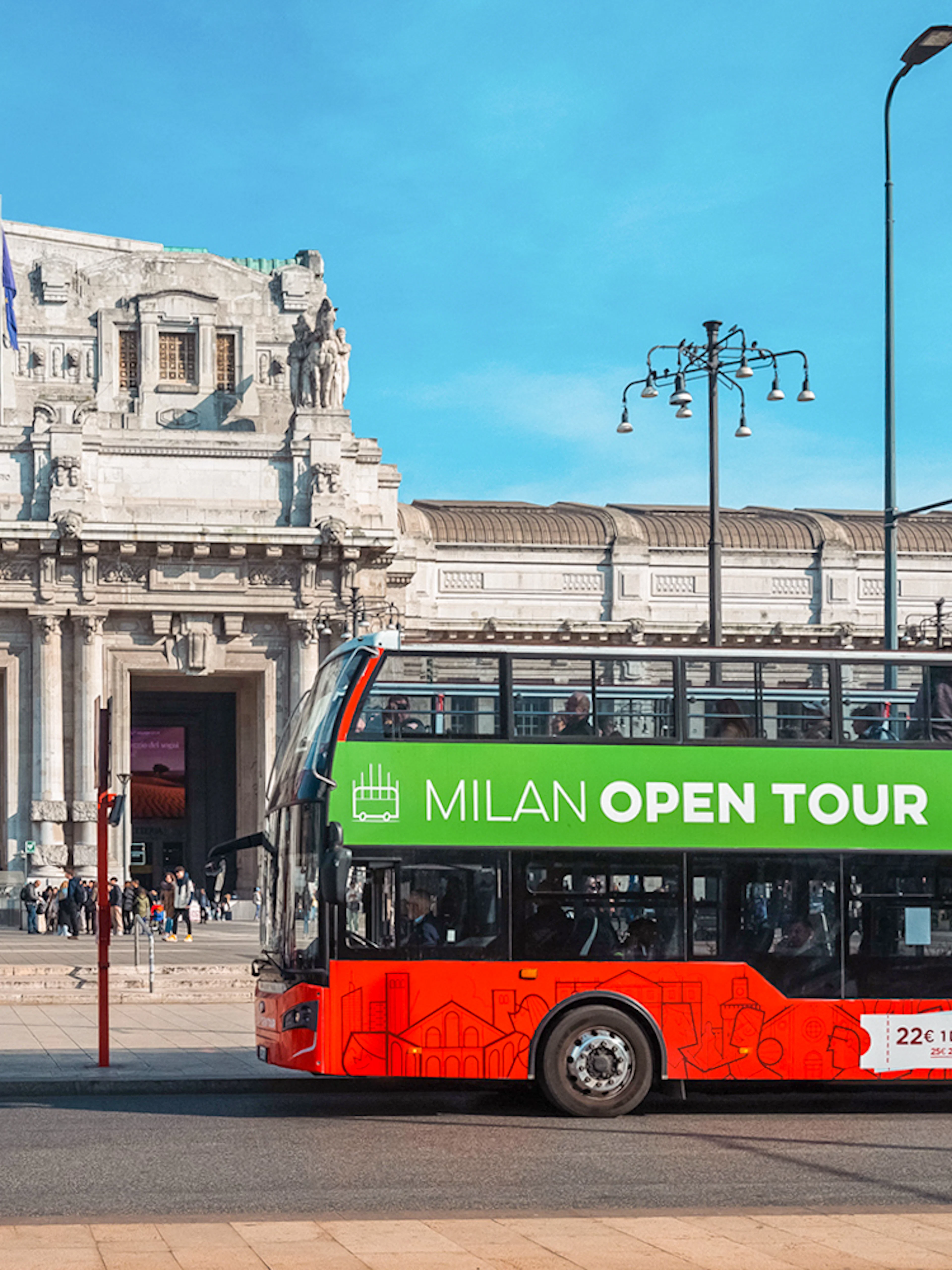 Hop-on hop-off bus in front of Milan Central Station during city tour.