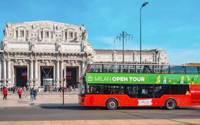 Hop-on hop-off bus in front of Milan Central Station during city tour.