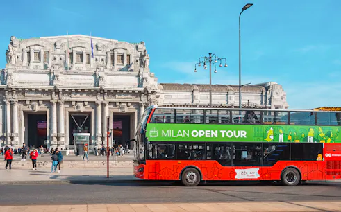 Hop-on hop-off bus in front of Milan Central Station during city tour.