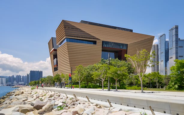 Exterior view of Hong Kong Palace Museum with modern architecture and surrounding greenery.