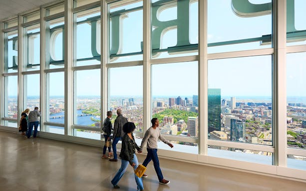 Visitors enjoying city views from View Boston observatory inside Prudential Tower.