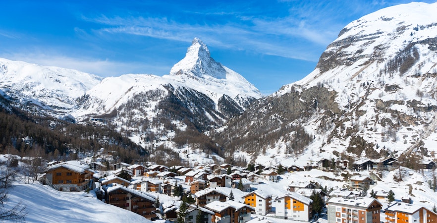 Zermatt village with snow-covered rooftops and Matterhorn mountain in the background, Switzerland.