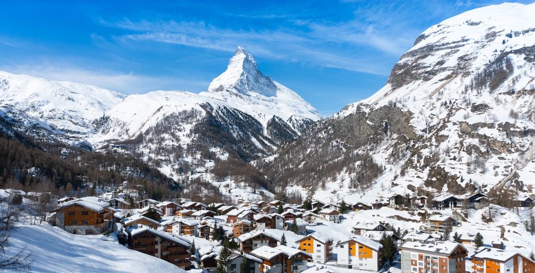 Zermatt village with snow-covered rooftops and Matterhorn mountain in the background, Switzerland.