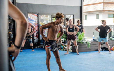 Beginners practicing Muay Thai boxing techniques in a Koh Samui training class.