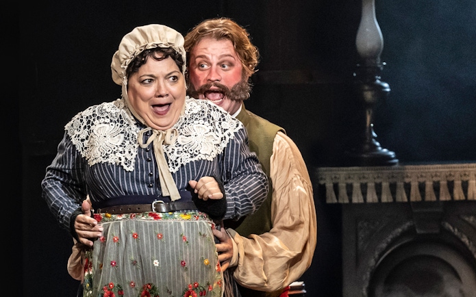 Actors performing a scene from the musical Oliver! on stage.