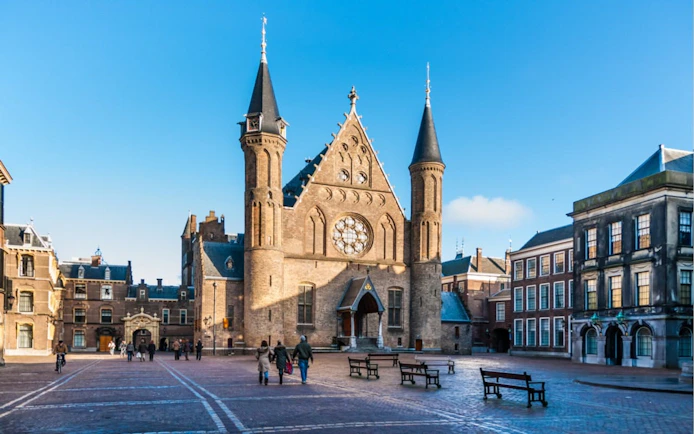 Binnenhof courtyard with Ridderzaal in The Hague, people walking.