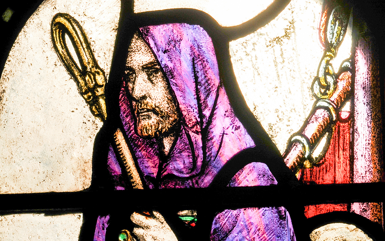 Stained glass depiction of Saint Columba with a staff.