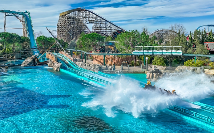 Blue Fire coaster loop with scenic backdrop and water splash at Europa-Park.