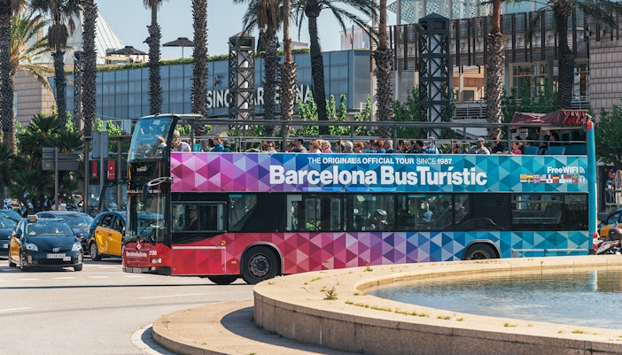 Barcelona cityscape with Barcelona Bus Turistic hop-on hop-off bus near Sagrada Familia.
