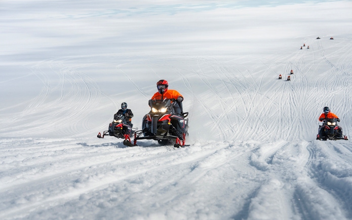 Snowmobilers riding on Langjökull Glacier in Iceland.