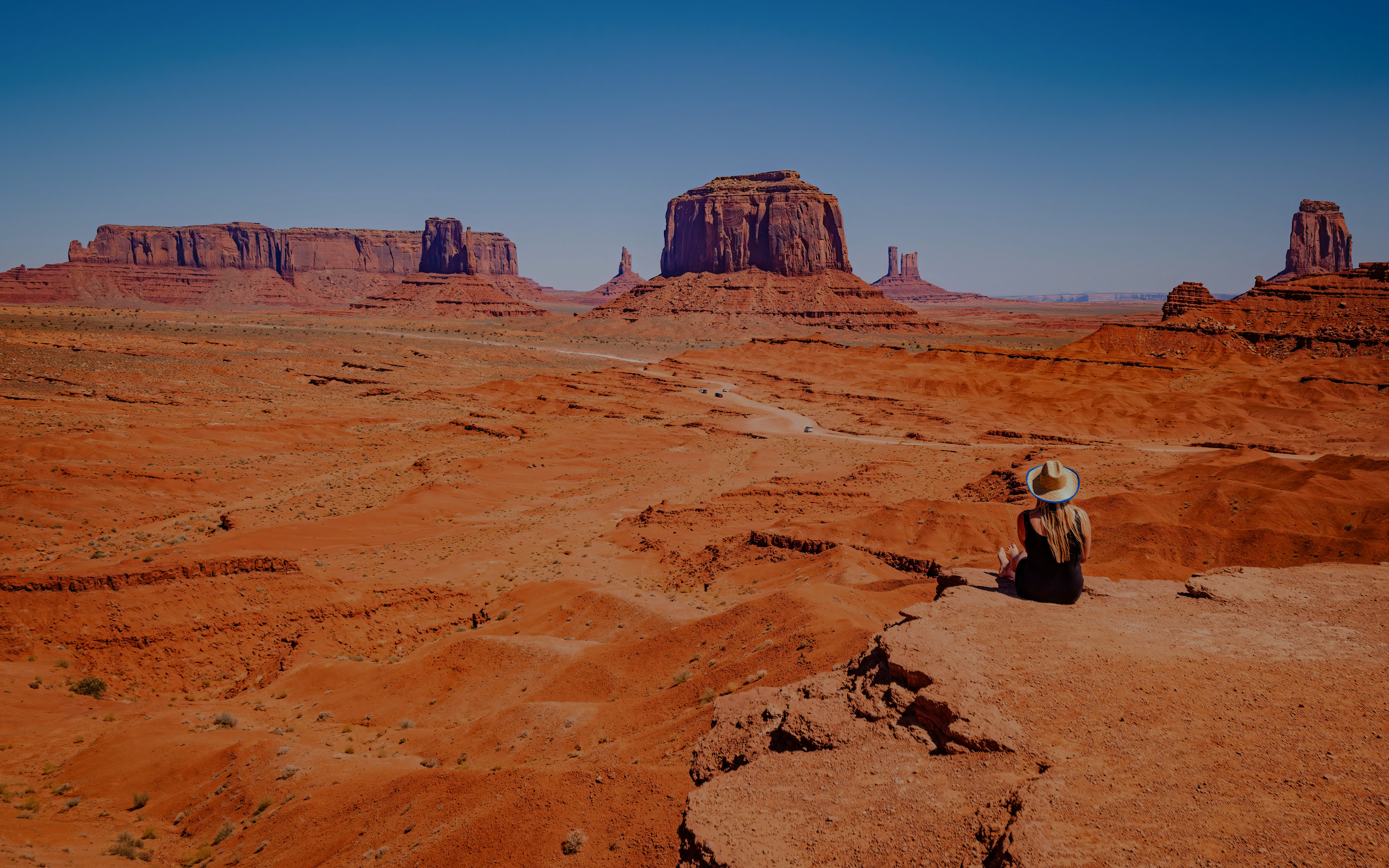 Guest enjoys sunrise view from John Ford Point, Monument Valley, with iconic red rock formations.