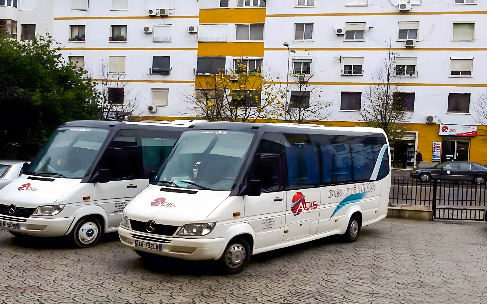 Buses parked outside a building for Tirana Airport transfer to Durres.