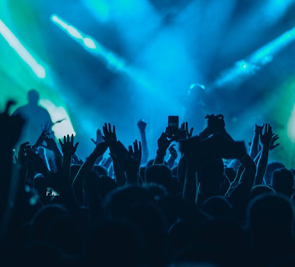 Crowd enjoying a concert with blue stage lights in Ushuaïa.