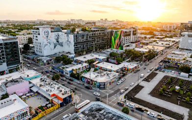 Aerial view of Wynwood Walls Museum in Miami featuring vibrant street art and murals at sunset.