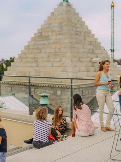 Group enjoying rooftop view in Copenhagen with historic architecture in the background.